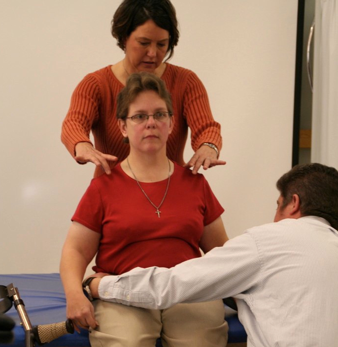 Two clinicians conduct a wheelchair assessment with a client.