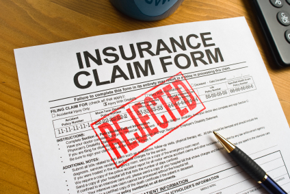 An insurance claim form is stamped with the word 'rejected.'
