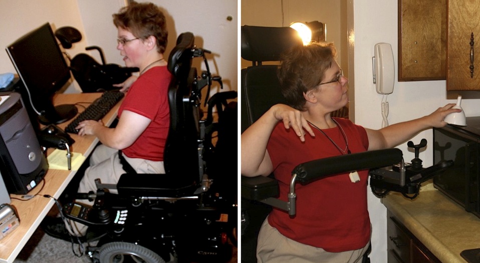 A woman navigates her home in her wheelchair sitting to use her home computer and moving into a standing position to reach high kitchen cabinets.