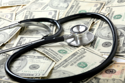 A stethoscope lays on a pile of money. 